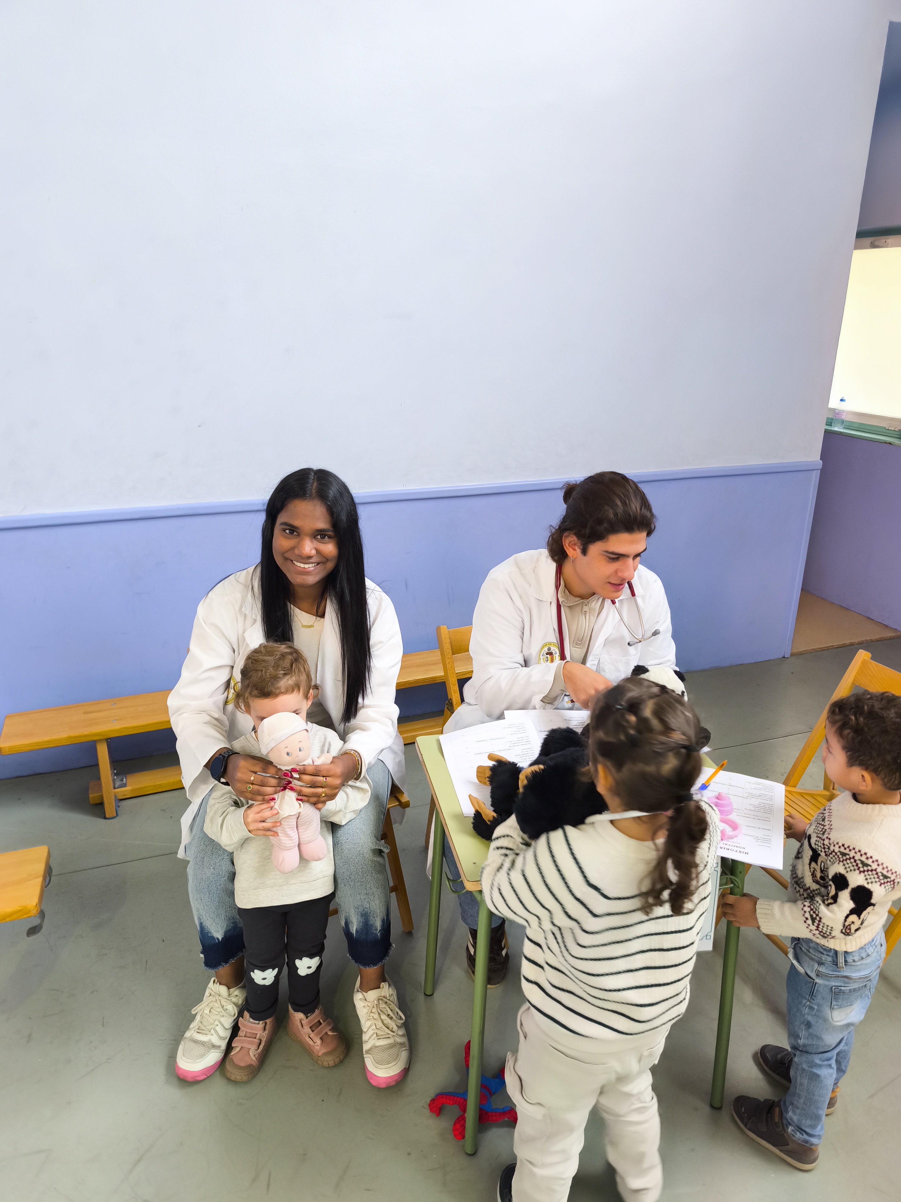 Estudiantes acompañan a los niños y a sus peluches durante una consulta del Hospital de Ositos
