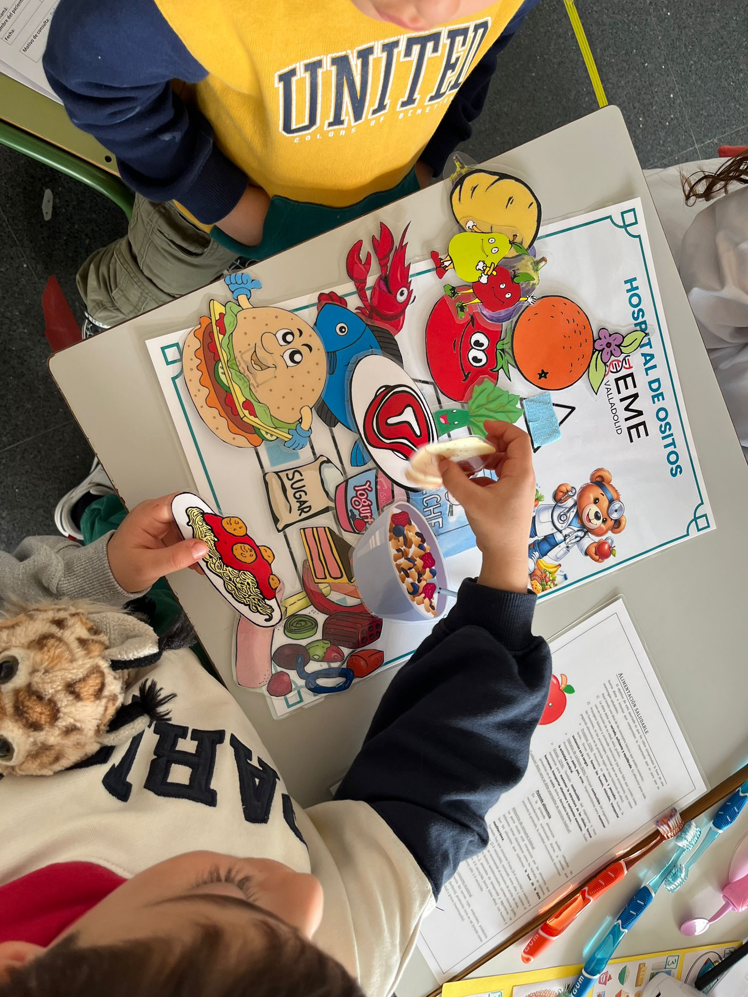 Niños participan con su peluche en un juego con dibujos de alimentos