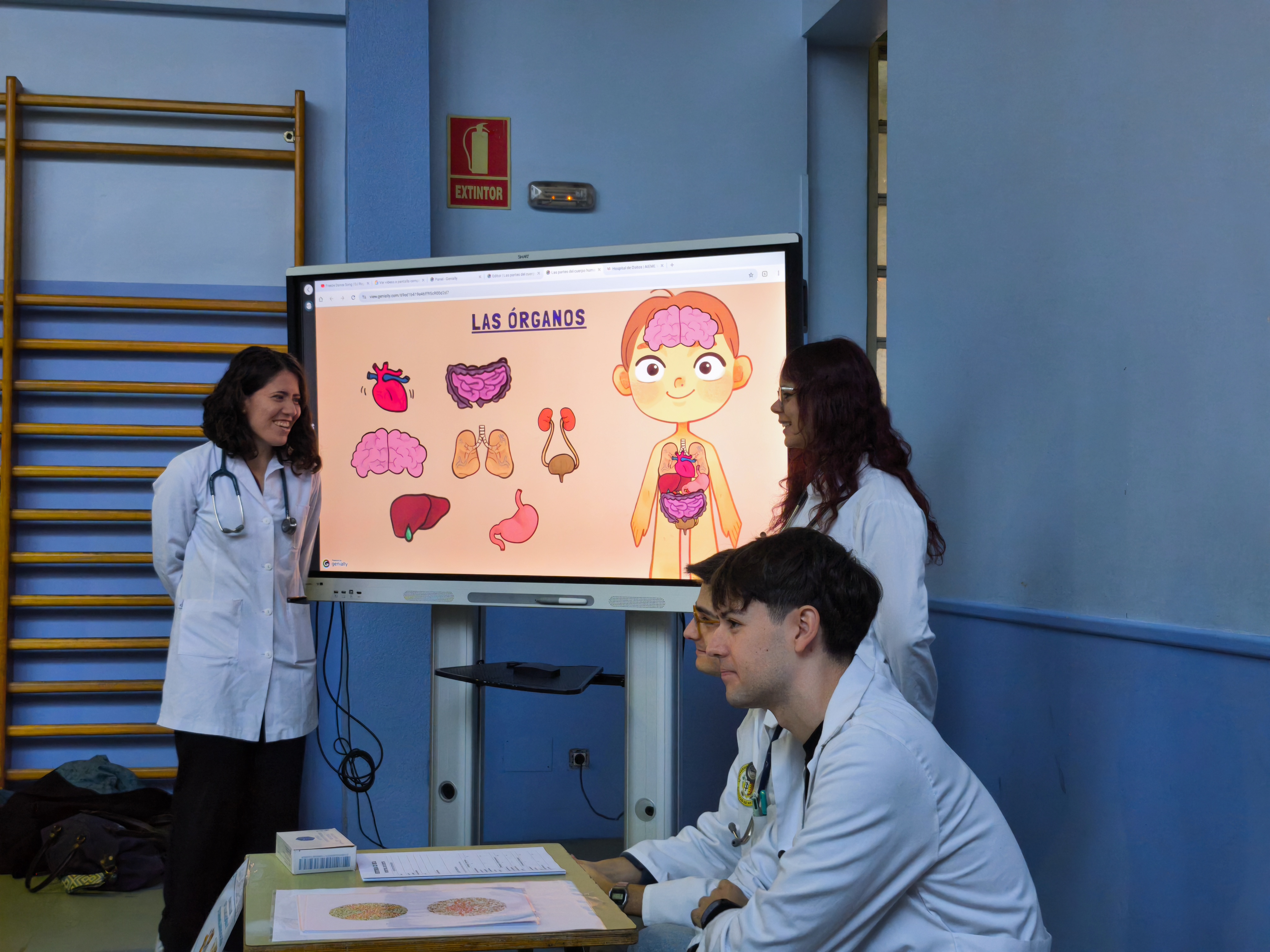 Estudiantes presentan una actividad sobre los órganos del cuerpo humano con una pantalla ilustrada