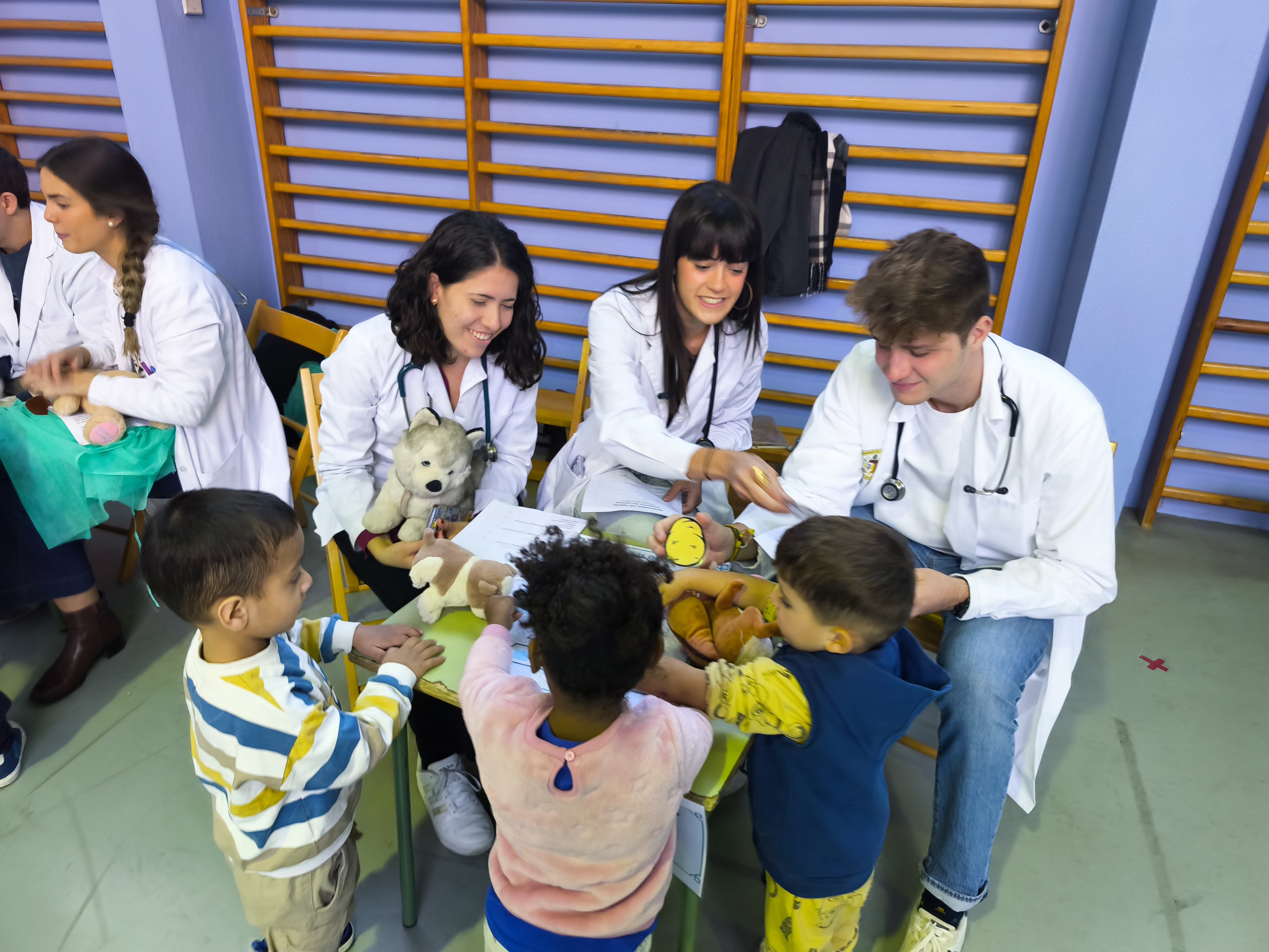 Niños y estudiantes comparten una consulta de juego con varios peluches en el Hospital de Ositos